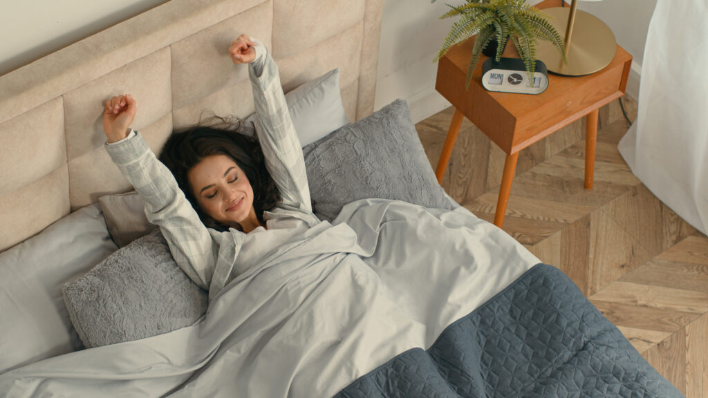 Happy woman stretching lying bed she got great sleep