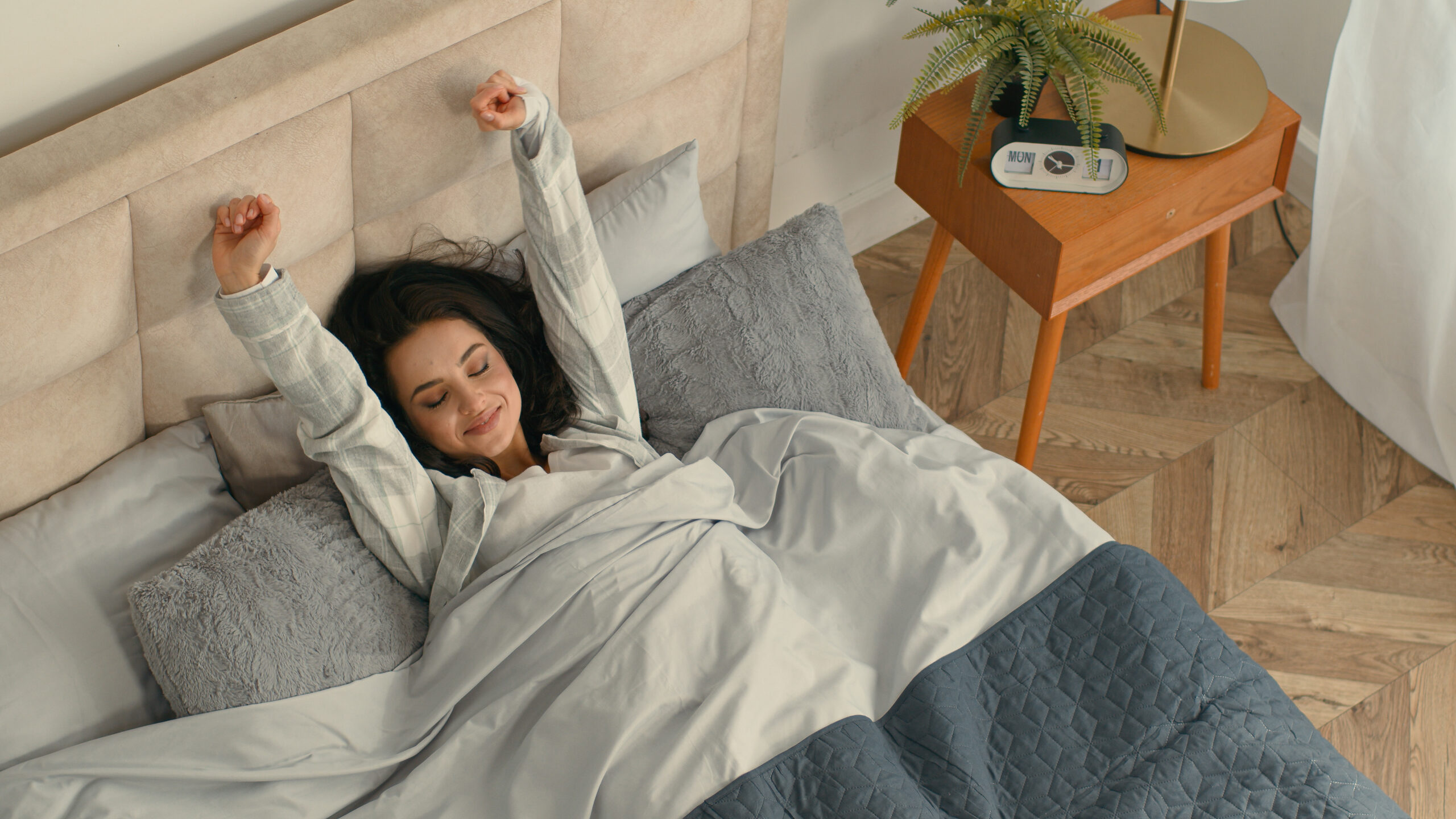 Happy woman stretching lying bed she got great sleep