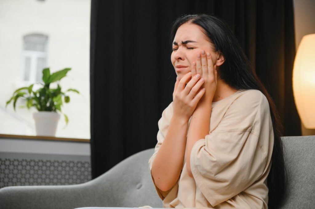 woman suffering from TMJ pain - Pure Health Dental Woman Suffering from Temporomandibular Joint Disorder (TMD) or TMJ